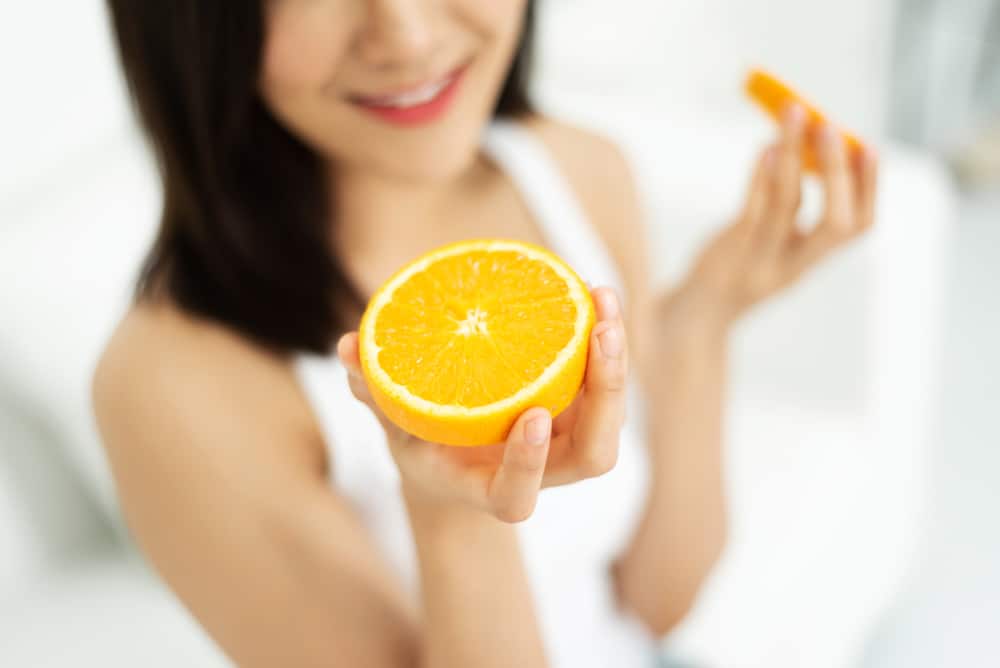 女人拿著剖半的柳丁